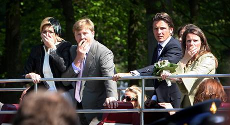 Nizozemsk korunn princ Willem-Alexander a jeho manelka princezna Mxima (vlevo) zden sleduj, jak idi osobnho vozu projd davem pi slavnostnm prvodu. (30. dubna 2009)
