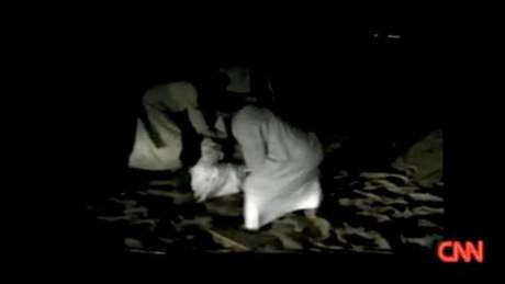 Zábr z videa zachycujícího, jak ejk Ísá bin Zajd Nahján muí obchodníka s obilím.