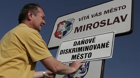 Místostarosta Miroslavi Roman Volf pipevuje na vjezdu do obce ceduli "Daov diskriminované msto" bhem protestu malých obcí (26. kvtna 2009)