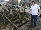 Premir Jan Fischer, kter odletl na inspekci do Moravskoslezskho kraje, se zdrav s vojky odstraujcmi na okraji Novho Jina kody po zplavch. (30.6.2009)