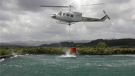 Vrtulník panlských hasi nabírá vodu, aby mohl hasit poár poblí Valencie (25.7.2009)