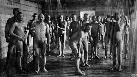 Italtí zajatci, kteí byli pedtím odviveni, se sprchují pod dohledem rakousko-uherské stráe.
