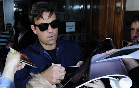 Robbie Williams se podepisuje fanoukm ped britským Radio One, kde pedstavil svj nový singl Bodies