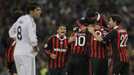 RADOST A SMUTEK. Fotbalisté AC Milán se objímají a oslavují: vdy vyhráli v Lize mistr na stadionu Realu Madrid. Radost svých bývalých spoluhrá pozoruje smutn Kaká, jen do Realu piel v lét.