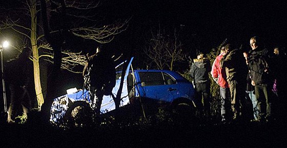 Kriminalisté prohlíejí okolí automobilu, ve kterém policie v Hajanech dopadla uprchlého vzn Pavla Tauchena a jeho manelku. (12. listopadu 2009)