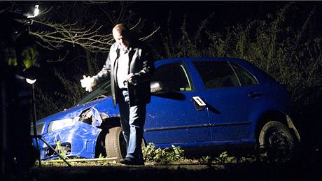 Kriminalisté prohlíejí okolí automobilu, ve kterém policie v Hajanech dopadla uprchlého vzn Pavla Tauchena a jeho manelku. (12. listopadu 2009)