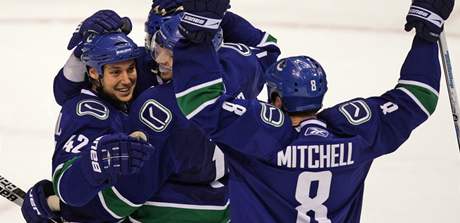 Zleva: Kyle Wellwood, Ryan Kesler, Alex Burrows (vzadu) a Willie Mitchell se radují z Wellwoodova prvního gólu sezony, který pomohl Vancouveru porazit Los Angeles.