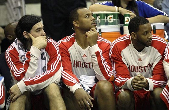 Tracy McGrady (vpravo) sedí na lavice Houstonu Rockets. Vlevo Luis Scola, uprosted Chuck Hayes.