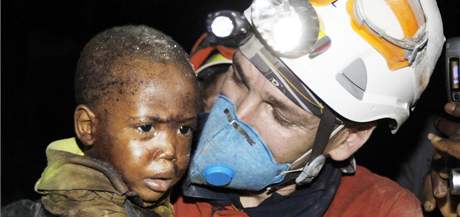 panlský záchraná nese malého chlapce, kterého vytáhli ivého z trosek poboeného domu. (15. ledna 2010)