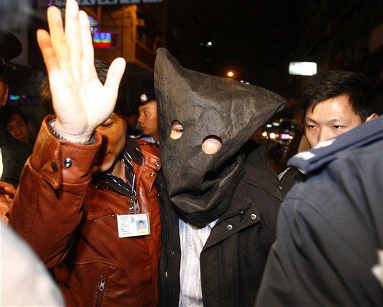 Policisté v Hongkongu odvádjí mue podezelého z toho, e hodil ze stechy lahve s kyselinou (10. ledna 2010)