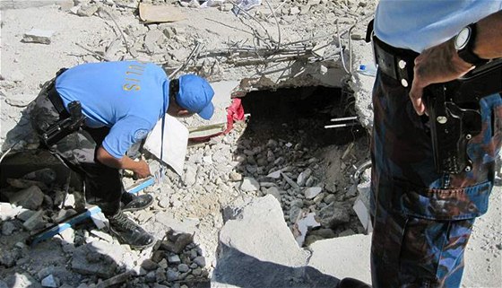 Filipíntí policisté prohledávají trosky zícené budovy OSN. (15. ledna 2010)