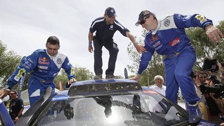 Carlos Sainz (vpravo) se svým spolujezdcem Lucasem Cruzem (vlevo) oslavují triumf na Dakaru mezi automobily