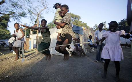 Dti skou pes vihadlo v provizornm stanovm tboe na okraji Port-au-Prince. (22. ledna 2010)