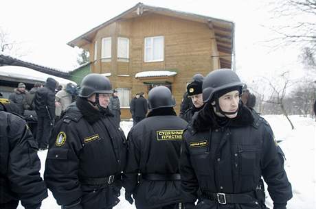 Soudní vykonavatelé a policisté u jednoho z dom v Reniku