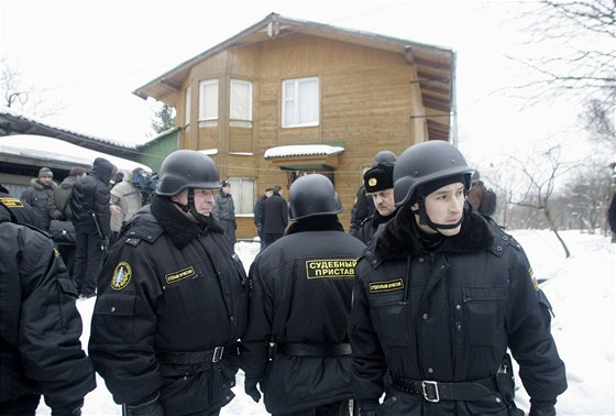 Soudní vykonavatelé a policisté u jednoho z dom v Reniku