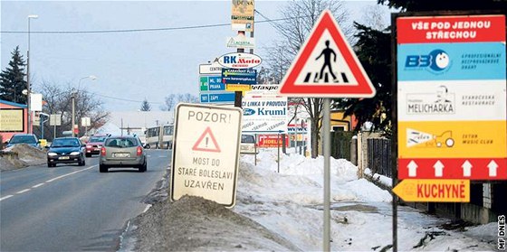 Na silnici II/610 v Brandýse nad Labem nkteré z reklamních cedulí zakrývají dopravní znaky.