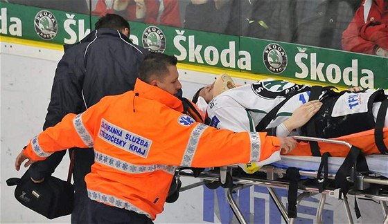 Zranný Luká Pabika z Mladé Boleslavi je odváen z ledové plochy po ataku litvínovského Jiího légra