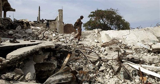 Mu chodí po ruinách jedné z budov v Port-au-Prince.