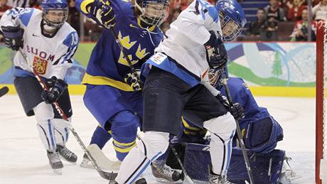 Finská hokejistka Michelle Karvinenová se snaí dorazit puk za záda védské brankáky Grahnové.