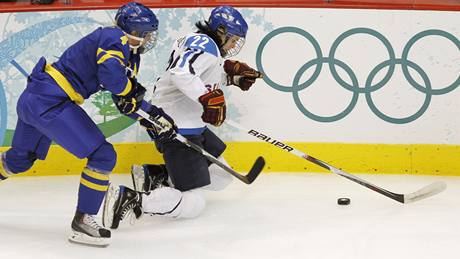 védská hokejistka Jenni Asserholtová stíhá soupeku z Finska Saaru Tuominenovou na hokejovém turnaji ZOH ve Vancouveru.