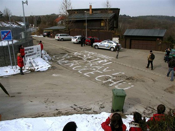 Transparent s nápisem "Neetete na zdraví Severoech!" a výzva "Martine, neeti na zdraví Severoech!" napsaná barvou na vozovce aktivisty Greenpeace ped domem éfa EZ Martina Romana.