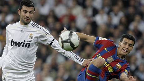 Raul Albiol, obránce Realu Madrid (vlevo), v souboji s Pedrem, útoníkem Barcelony