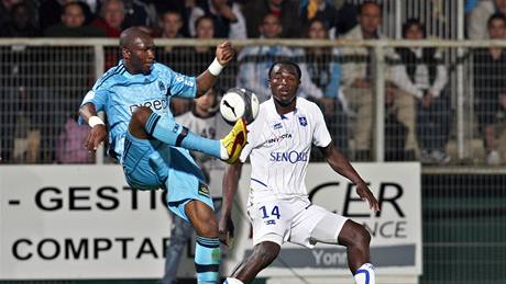 Stephane Mbia (vlevo) z Marseille krotí míč před Dennisem Oliechem z Auxerre Stephane Mbia (vlevo) z Marseille krotí míč před Dennisem Oliechem z Auxerre