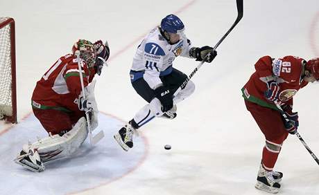 HOP. Finsk hokejista Leo Komarov uskakuje stele tak, aby co nejvce zastnil vhled branki Bloruska Andreji Mezinovi.
