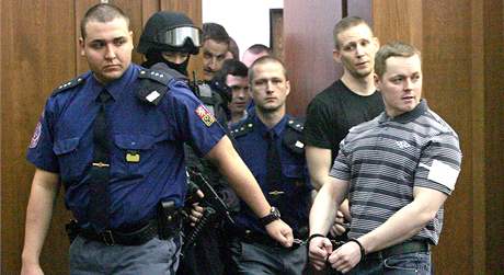 Eskorta po dvoumsíní pestávce pivede do soudní sín tyi mladíky, kteí  v dubnu 2009 zapálili dm romské rodiny ve Vítkov.