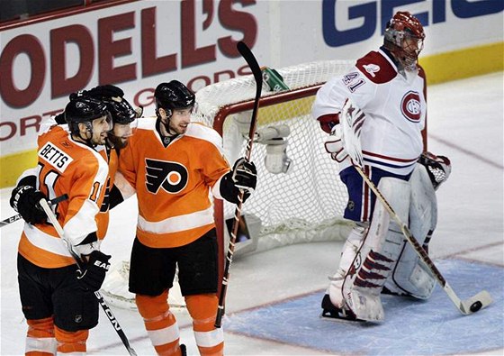 Radost hokejist Philadephie, s ní kontrastuje smutek brankáe Montrealu Jaroslava Haláka. 