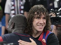 Kapitn fotbalov Barcelony Carles Puyol gratuluje k euroligovmu triumfu basketbalistovi Bonifaci NDongovi. Vpravo pihl Xavi