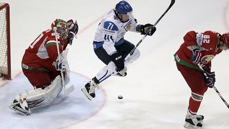 HOP. Finský hokejista Leo Komarov uskakuje stele tak, aby co nejvíce zastínil výhled brankái Bloruska Andreji Mezinovi.