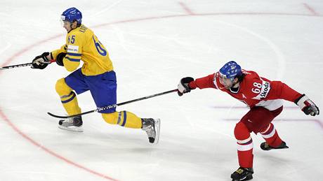 eský hokejista Jaromír Jágr se pokouí zastavit unikajícího véda Erika Karlssona.