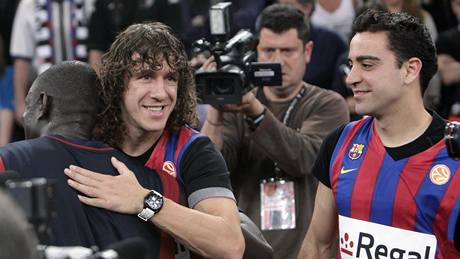Kapitán fotbalové Barcelony Carles Puyol gratuluje k euroligovému triumfu basketbalistovi Bonifaci N´Dongovi. Vpravo pihlíí Xavi