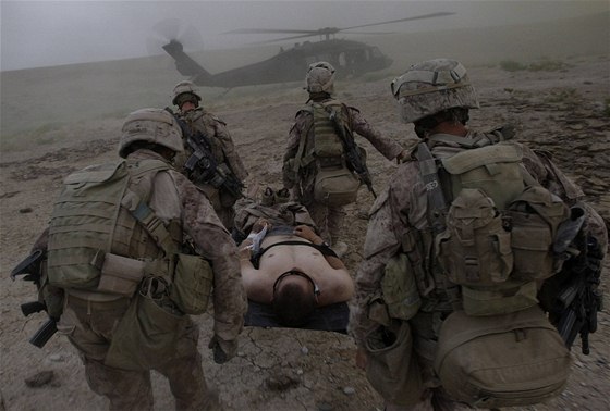 Vojentí lékai nesou písluníka americké námoní pchoty do helikoptéry v provincii Helmand (6. ervna 2009)