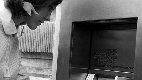 Rok 1968. Dívka v centru Londýna vybírá peníze z  jednoho z prvních bankomat.