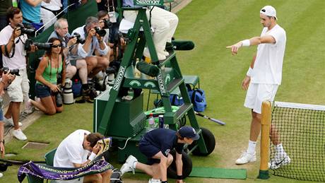 RADOST A SMUTEK. John Isner (vpravo) slaví zatímco Nicolas Mahut po poráce schoval hlavu do runíku