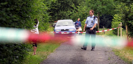 Policie u chaty v osad Kamenná u Ae, kde byla zavradna 22letá dívka