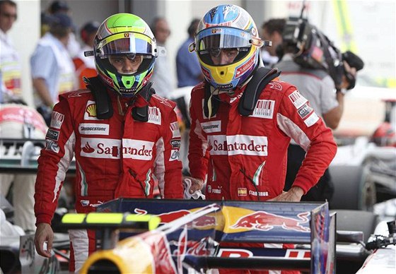 NEMLI JSME NA N. Piloti stáje Ferrari Felipe Massa (vlevo) a Fernando Alonso zamylen hledí na monopost Red Bullu. Práv jezdci této stáje ovládli kvalifikaci na okruhu Sliverstone a nechali vechny konkurenty za sebou.