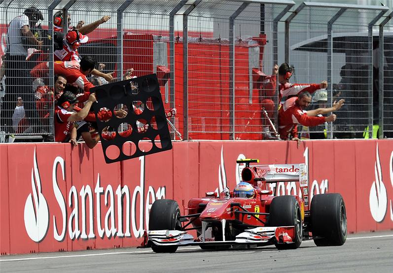 VÍTZ. Fernando Alonso z Ferrari projel cílem ve Velké cen Nmecka jako první.