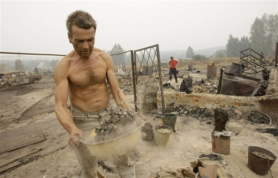 Oleg Michajlov se probírá ohoelými troskami svého domu v obci Kartonosovo v Rjazaské oblasti asi 180 kilometr jihovýchodn od Moskvy (12. srpna 2010)