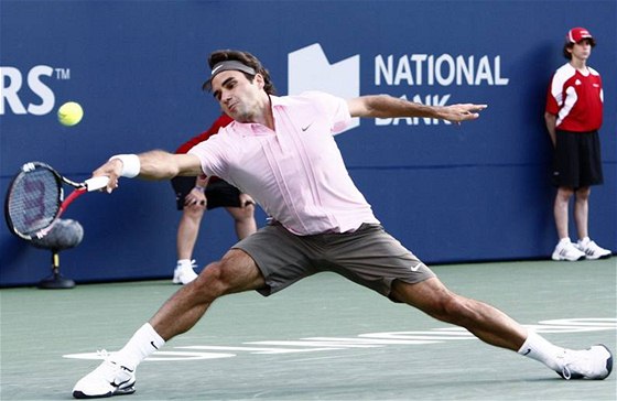 STÍHÁM. výcarský tenista Roger Federer se natahuje po míku a jet ho stíhá vybrat.