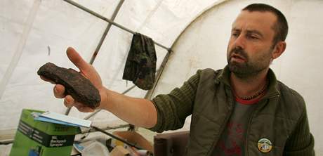 Petr Pinc ukazuje kus dna keramické nádoby, který s kolegy nali pi przkumu...