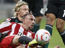 Franck Ribery (vpravo) z Bayernu Mnichov na zemi kontroluje m, za nm le Simon Kjaer  z Wolfsburgu. 
