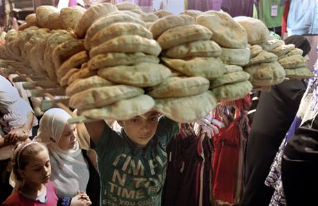 Egyptsk chlapec nese v Khie tc s arabskm chlebem v pedveer svtku d al-fitr
