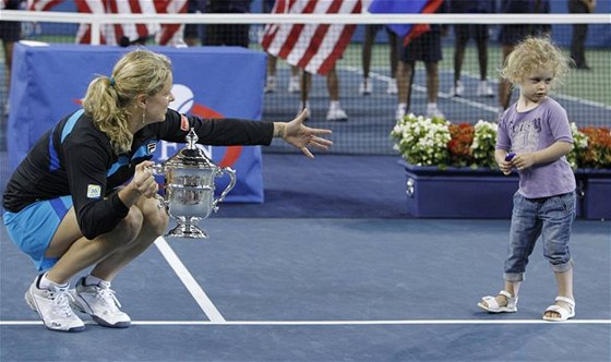 Tenistka Kim Clijstersová k sob volá svou dceru Jadu. V ruce drí trofej pro vítzku US Open.