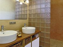 Koupelna je zajmavou kombinac keramick dlaby, bentskho tuku, prodnho deva a skla. Podlahu ve spre pokrv mozaika.