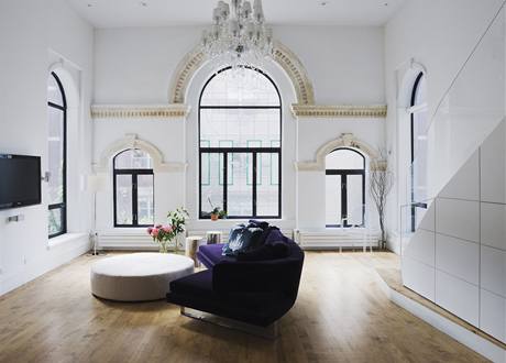 Hlavní obytná část penthousu v prvním patře. Obrovská původní okna dokonale prosvětlují prostor. Minimalistické zařízení nevyžadovalo více, než jen švestkovou pohodlnou sedačku Hlavní obytná část penthousu v prvním patře. Obrovská původní okna dokonale prosvětlují prostor. Minimalistické zařízení nevyžadovalo více, než jen švestkovou pohodlnou sedačku