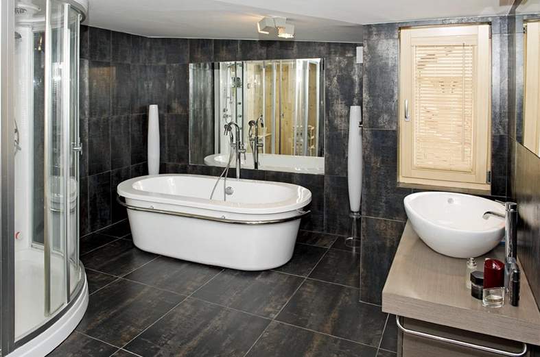 Zrcadlo jet násobí velkorysý prostor koupelny, kam se vela vana, sprchový kout, ale i sauna