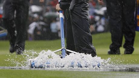 První kolo Ryder Cupu 2010 - lenové údrby vyhánjí vodu z green.